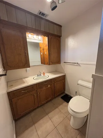 a bathroom with a toilet a sink a mirror and vanity