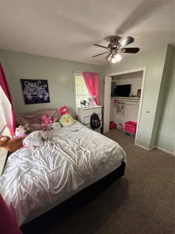 a bedroom with a bed a dresser and a flat screen tv