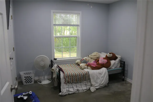 a bed sitting in a bedroom next to a window