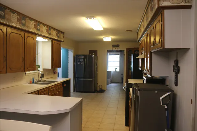 a kitchen with sink refrigerator and cabinets