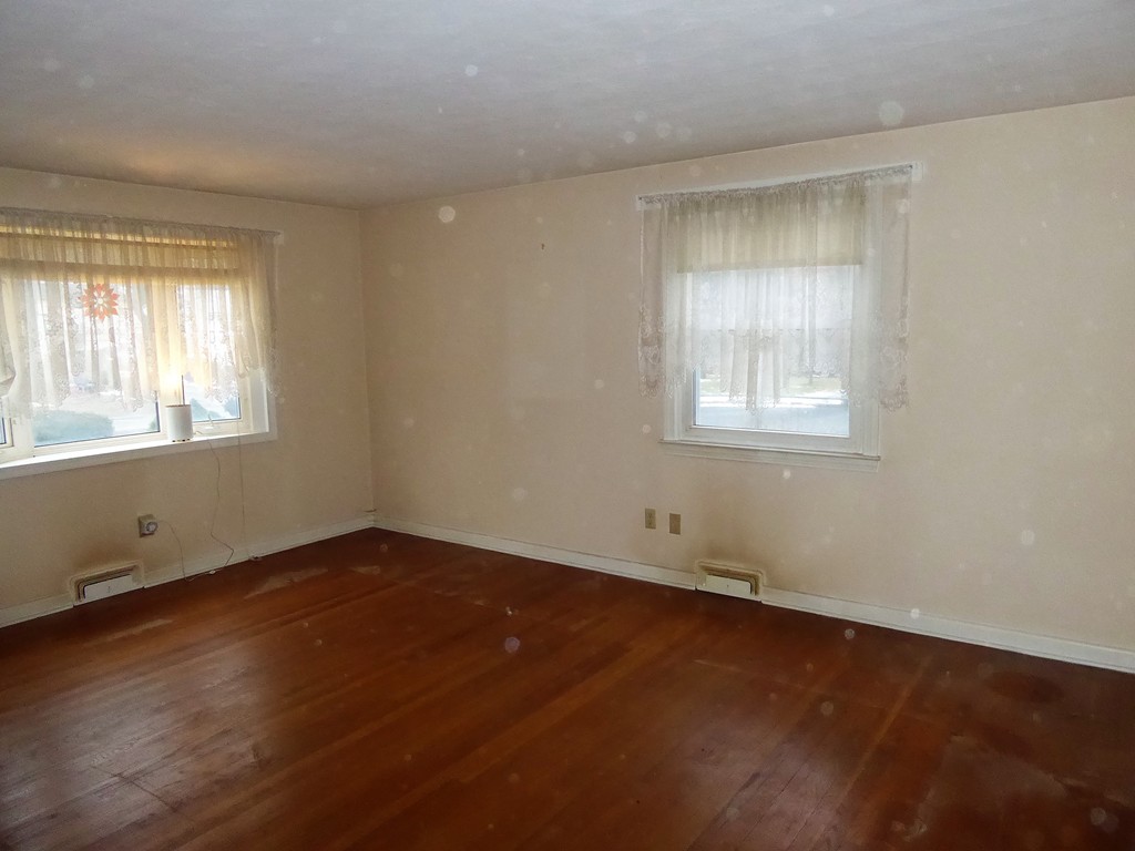 100 Hudson Street Springfield, MA 01118 - Photo 3 of 30 an empty room with wooden floor and windows