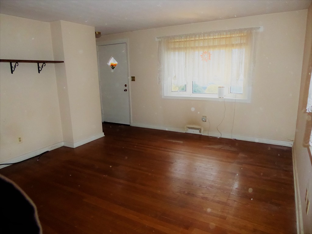 100 Hudson Street Springfield, MA 01118 - Photo 5 of 30 an empty room with wooden floor and windows