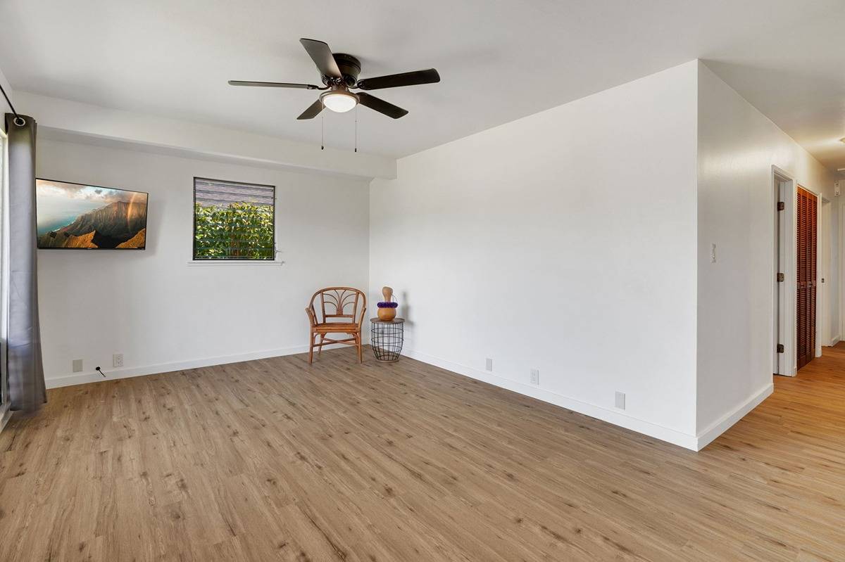 4920 Aliali Road, Unit 11 Kapaa, HI 96746 - Photo 5 of 30 a view of a livingroom with wooden floor and a ceiling fan