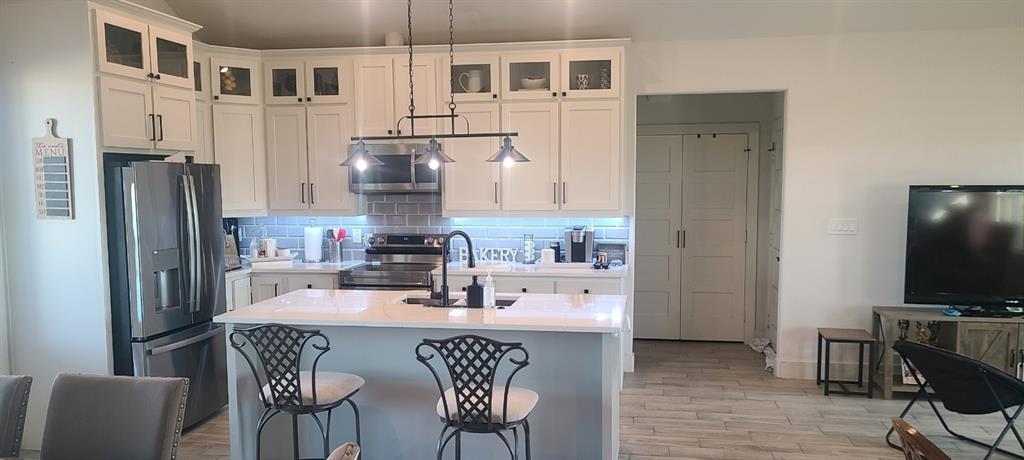 1589 Stiles Road Whitesboro, TX 76273 - Photo 9 of 22 a kitchen with stainless steel appliances granite countertop a dining table chairs refrigerator and sink
