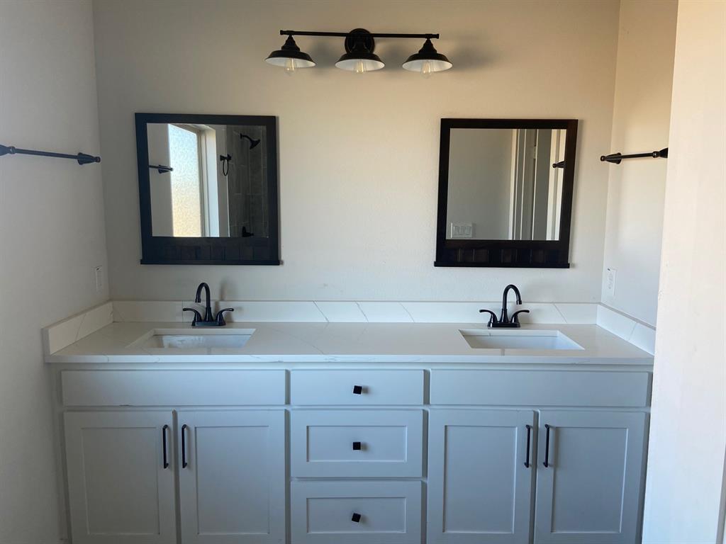 1589 Stiles Road Whitesboro, TX 76273 - Photo 10 of 22 a bathroom with a sink and two mirror