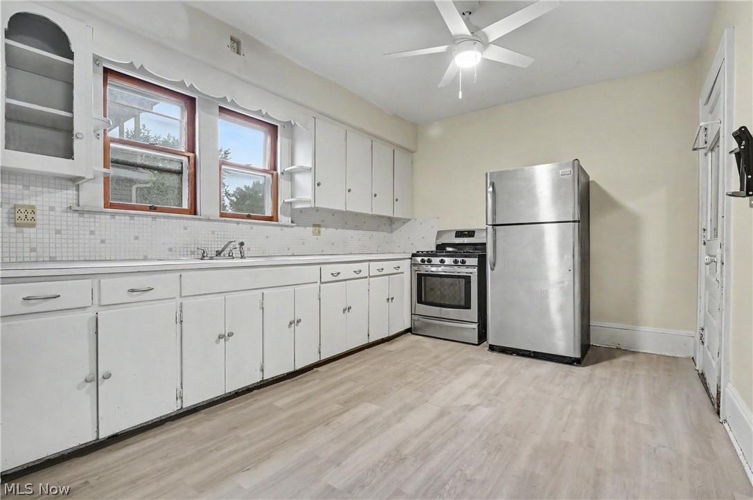 456 Delmar Avenue Akron, OH 44310 - Photo 8 of 27 Kitchen featuring wood-finish flooring, white cabinetry, a built-in stainless steel range, and a stainless steel refrigerator