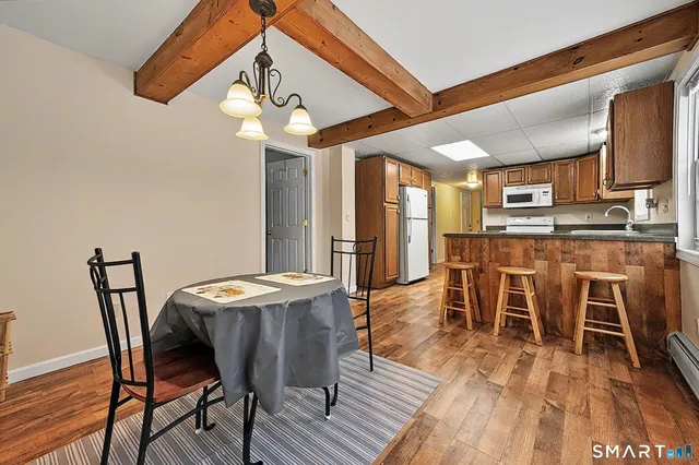 a dining room with furniture a chandelier and wooden floor