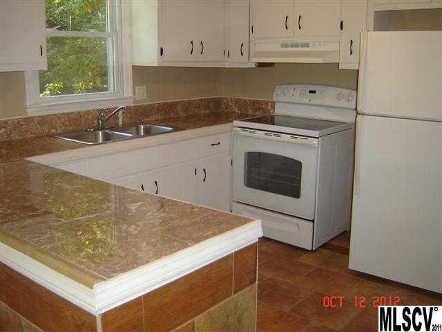 4122 Beach Road Hudson, NC 28638 - Photo 14 of 20 a kitchen with granite countertop a sink stainless steel appliances and white cabinets