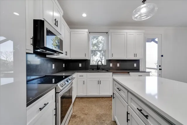 a kitchen with stainless steel appliances granite countertop a sink a stove and cabinets