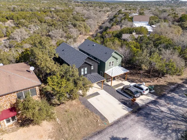 an aerial view of a house with a yard and lake view