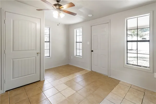 an empty room with closet and windows