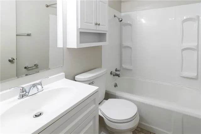 a view of a house with a small yard and large tree