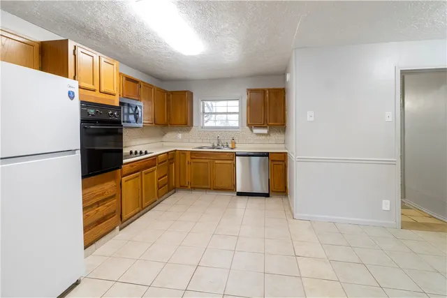 a kitchen with stainless steel appliances granite countertop a refrigerator sink and cabinets