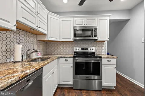 a kitchen with stainless steel appliances granite countertop a stove microwave and sink