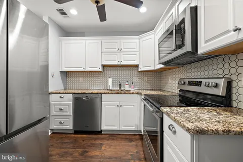 a kitchen with stainless steel appliances granite countertop a stove sink and cabinets