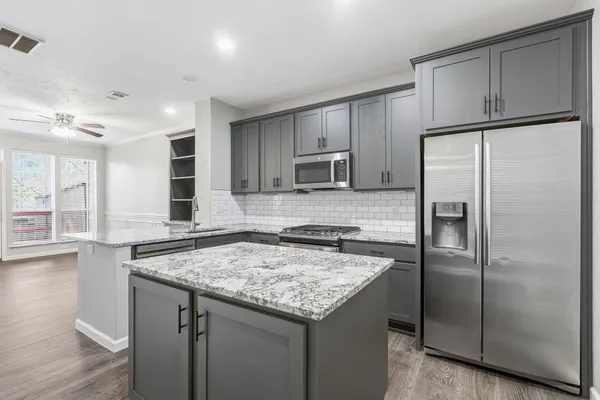 a kitchen with granite countertop a refrigerator and a sink