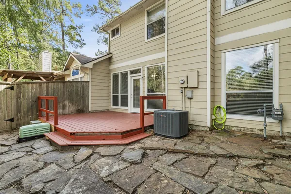 a backyard of a house with barbeque and wooden floor
