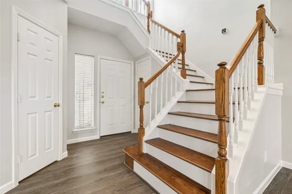 a view of staircase with wooden floor and white walls