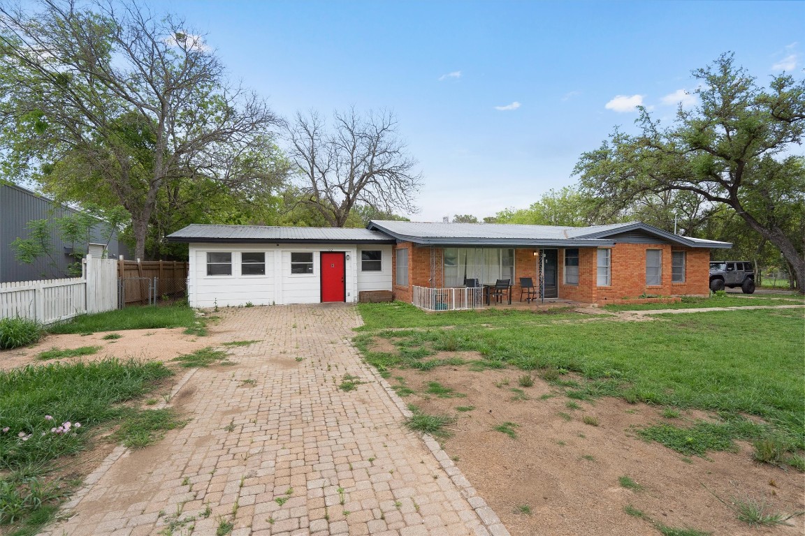 a view of a yard in front of a house with large tree