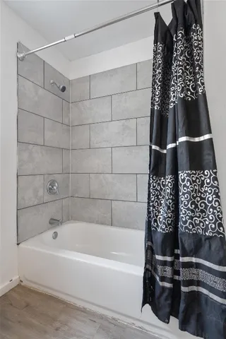 a bathroom with a bathtub and shower