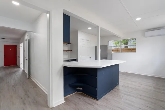 a kitchen with kitchen island a sink cabinets and wooden floor