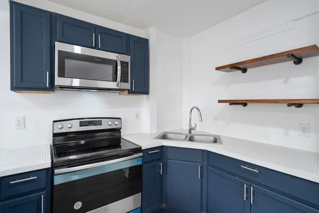 a kitchen with a sink stove and microwave