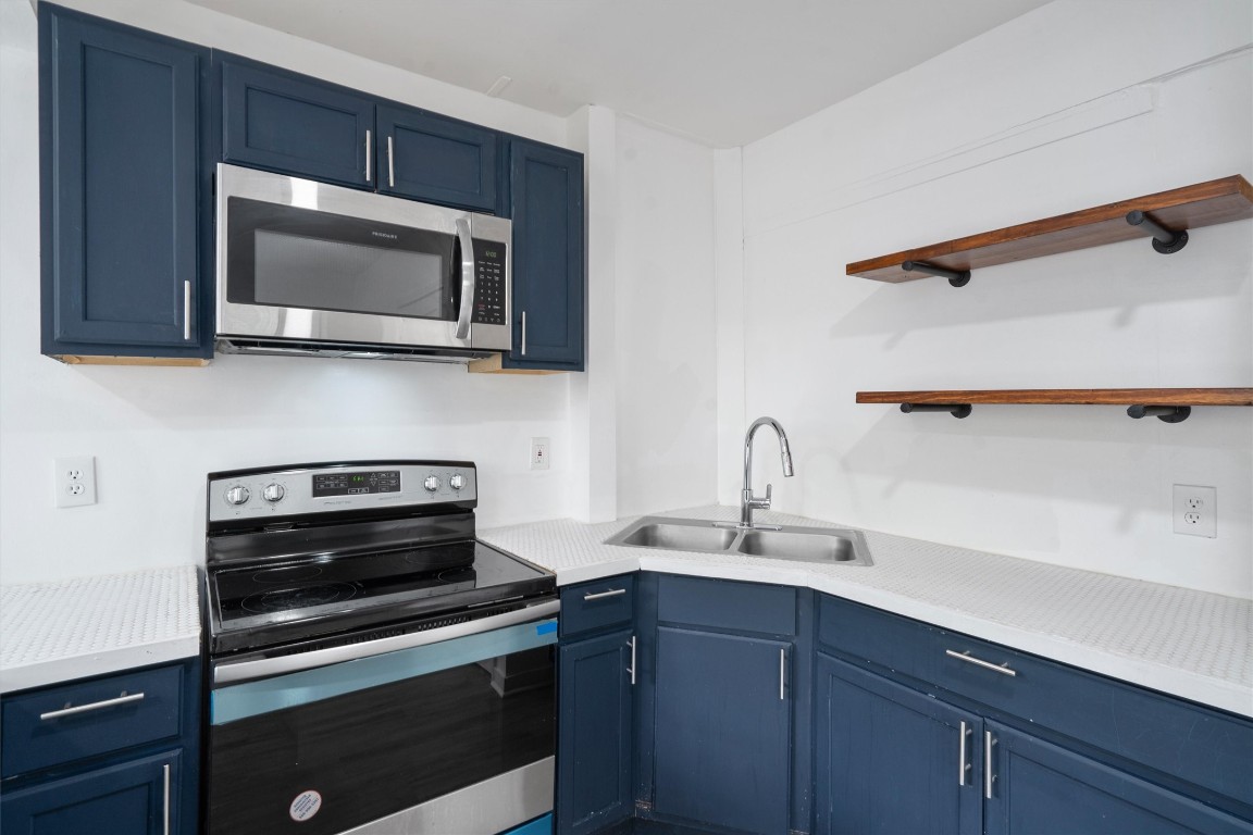 10205 Old Manchaca Road, Unit B Austin, TX 78748 - Photo 19 of 24 a kitchen with a sink stove and microwave