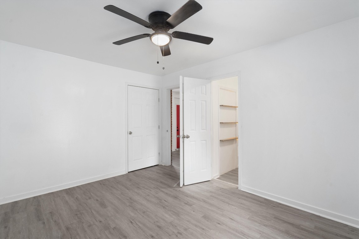 10205 Old Manchaca Road, Unit B Austin, TX 78748 - Photo 6 of 24 an empty room with wooden floor and ceiling fan