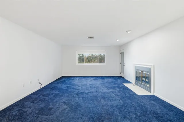 an empty room with a fireplace and window