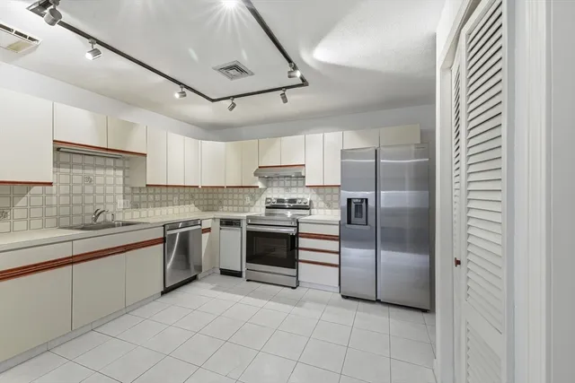 a kitchen with cabinets and stainless steel appliances