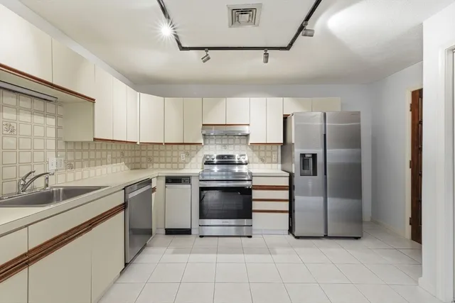 a kitchen with cabinets stainless steel appliances and a sink
