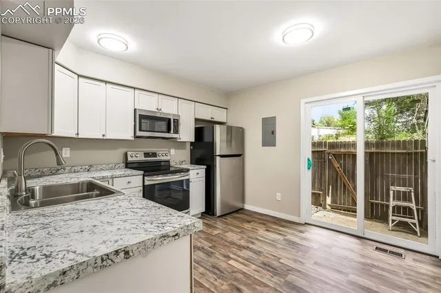 a kitchen with stainless steel appliances granite countertop a sink stove microwave and refrigerator