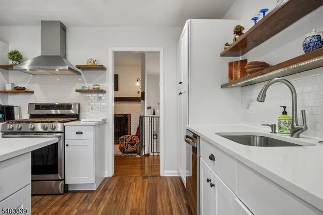 a kitchen with stainless steel appliances granite countertop a sink and wooden cabinets