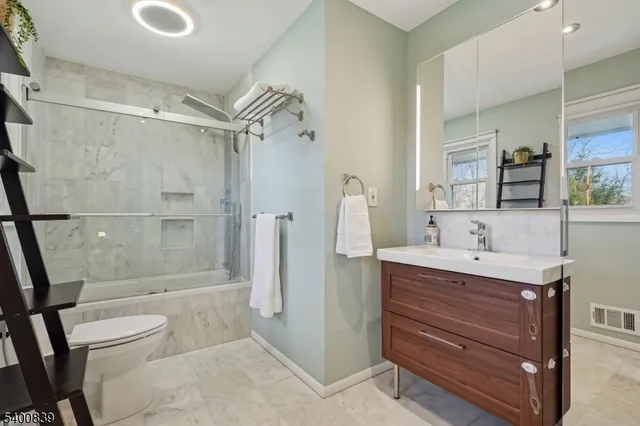 a bathroom with a double vanity sink toilet and shower