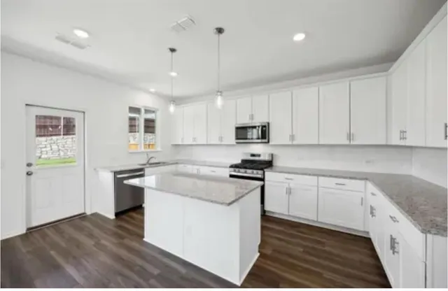 a kitchen with stainless steel appliances granite countertop a stove and a sink