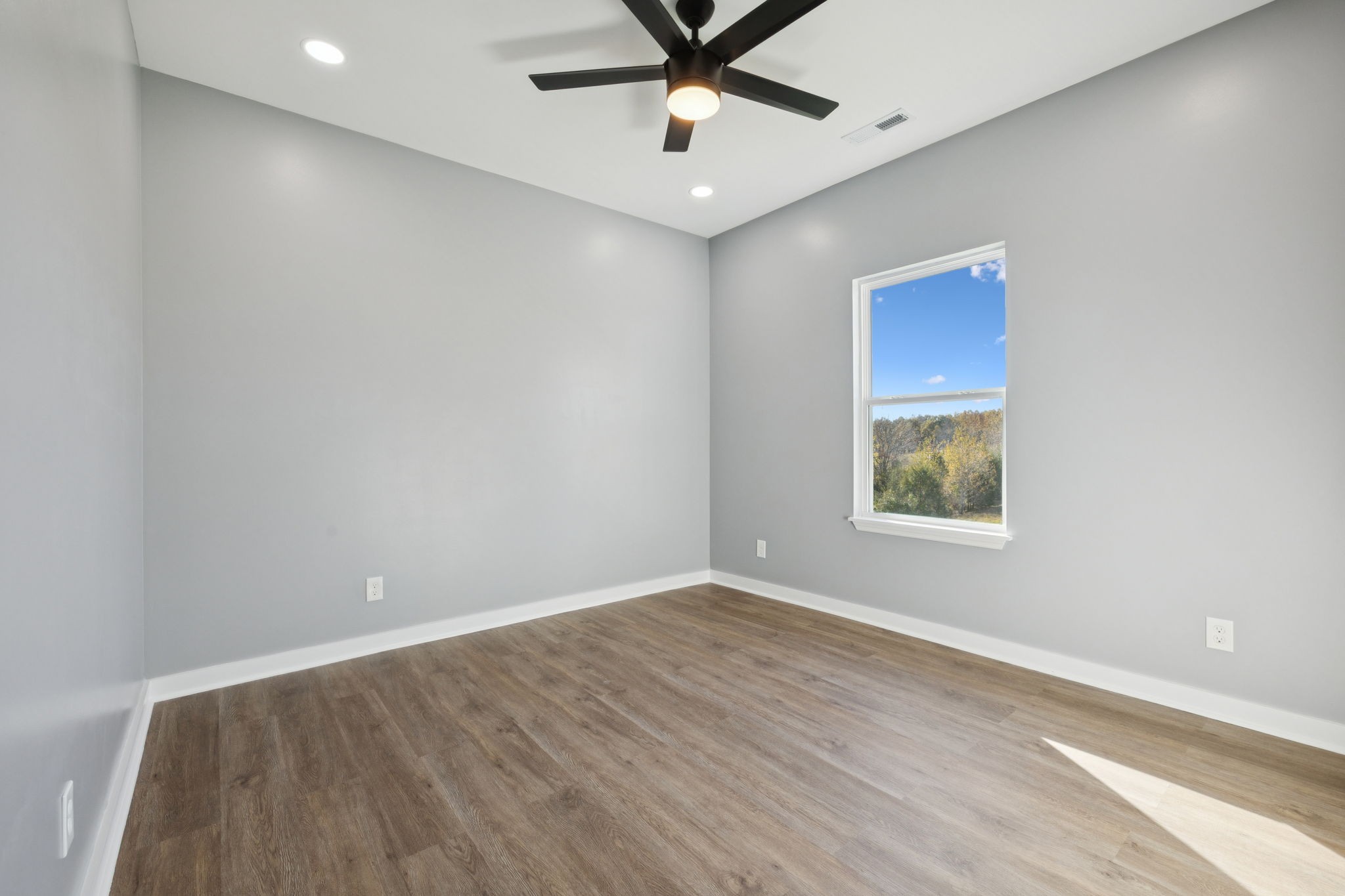 10154 Rocky Point Road Bon Aqua, TN 37025 - Photo 17 of 26 an empty room with windows and fan