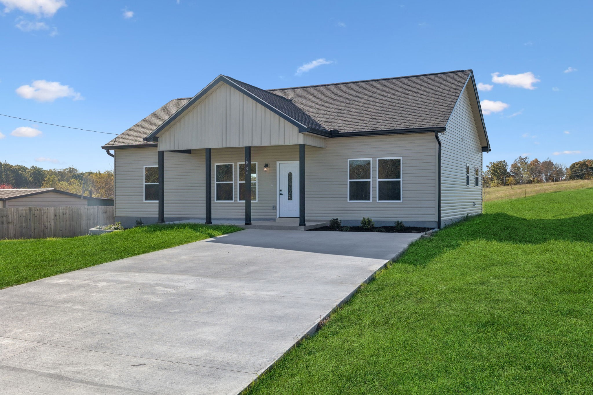 10154 Rocky Point Road Bon Aqua, TN 37025 - Photo 3 of 26 a front view of a house with a yard and garage