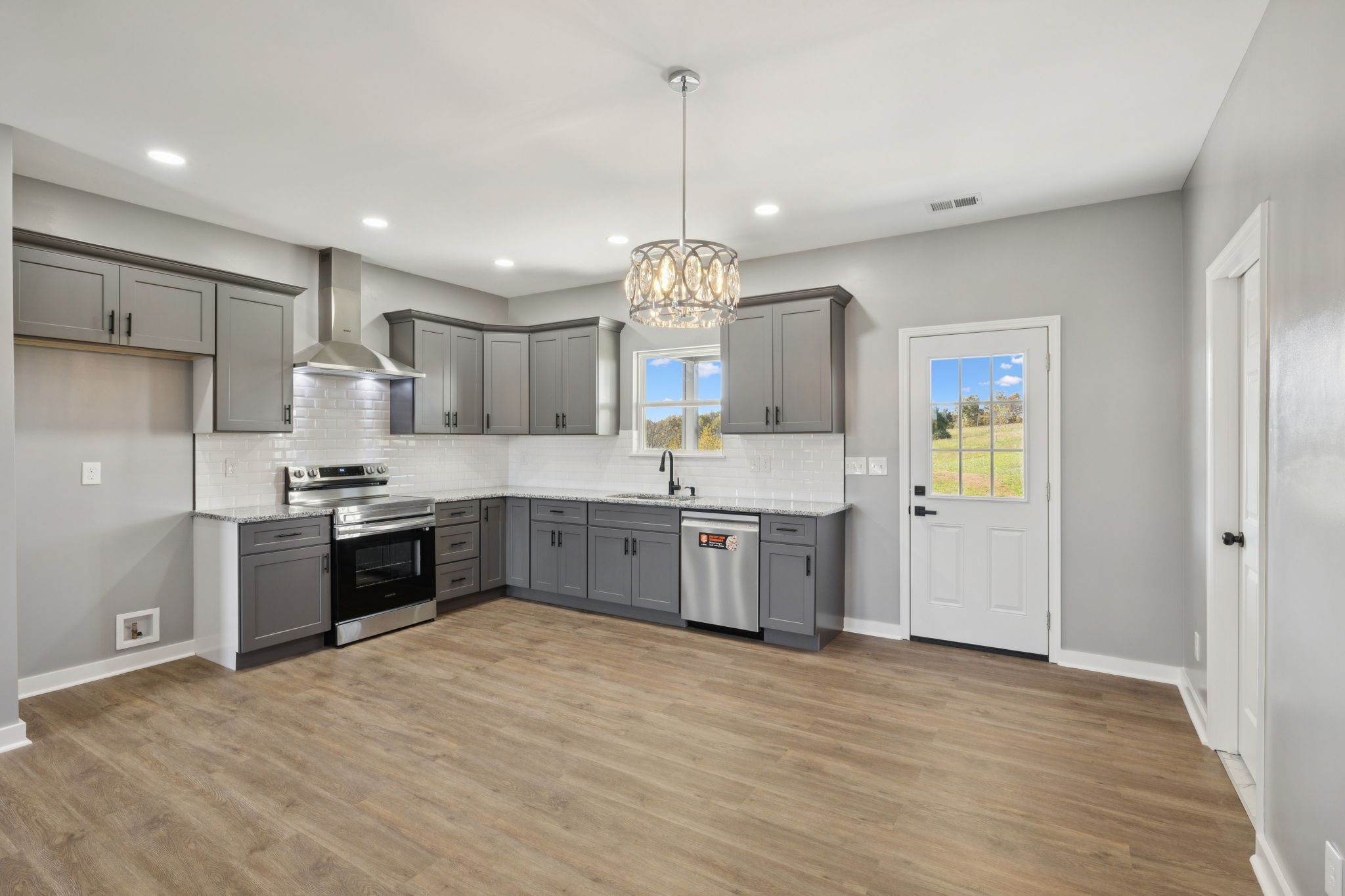 10154 Rocky Point Road Bon Aqua, TN 37025 - Photo 9 of 26 a large kitchen with a large counter top a sink stainless steel appliances and cabinets