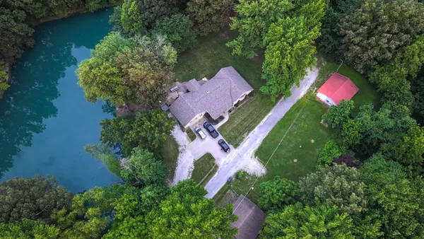 an aerial view of a house with outdoor space and a lake view