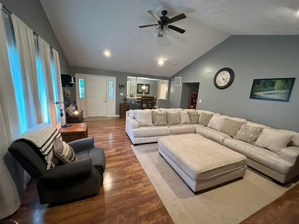 a living room with furniture and a wooden floor