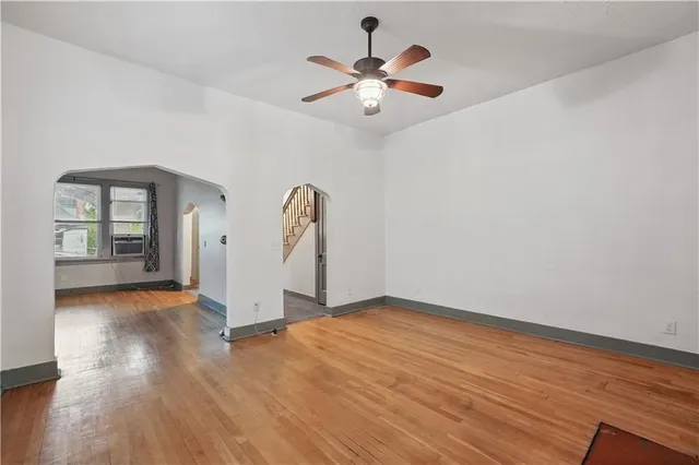 a view of an empty room with a window and wooden floor