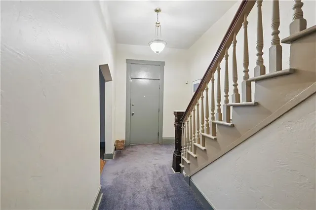 an empty room with windows and fireplace