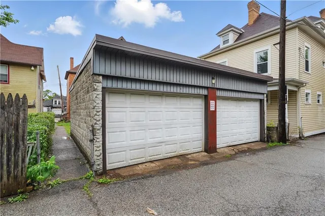 a view of an empty room with wooden floor fireplace and a window