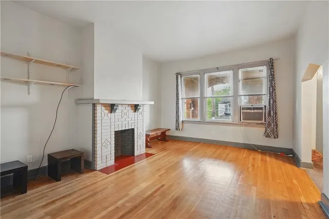 an empty room with windows and fireplace