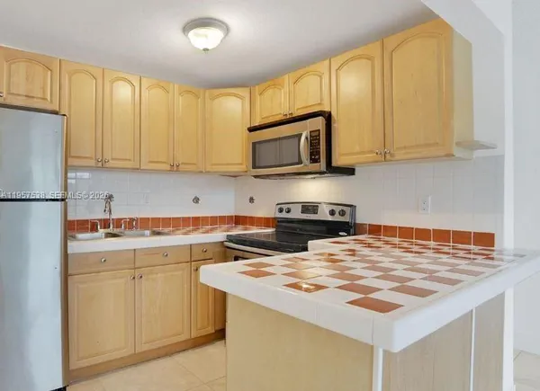 a kitchen with a sink a stove and cabinets