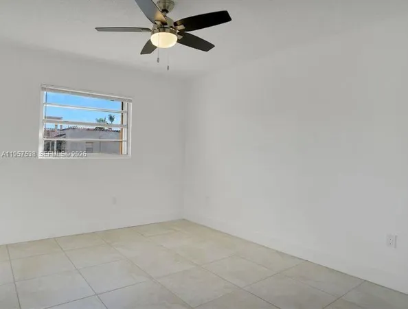 an empty room with a window and a fan