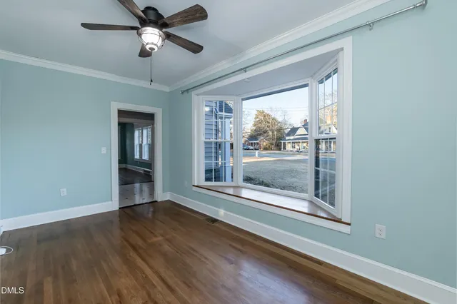 a view of an empty room with wooden floor