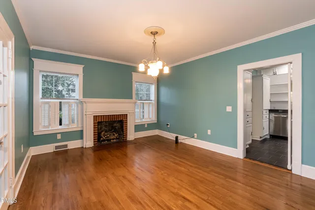 a view of a hallway with wooden floor and a livingroom