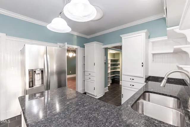 a kitchen with stainless steel appliances a stove a microwave and white cabinets