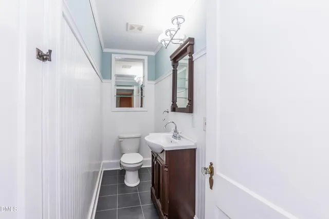 a view of an empty room with wooden floor and window